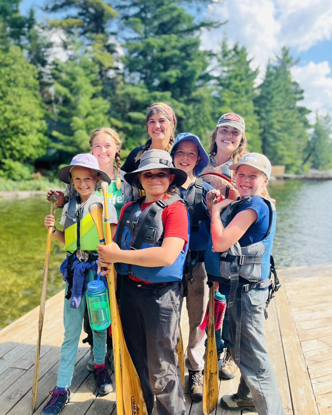 Kids on dock with paddles and life jackets