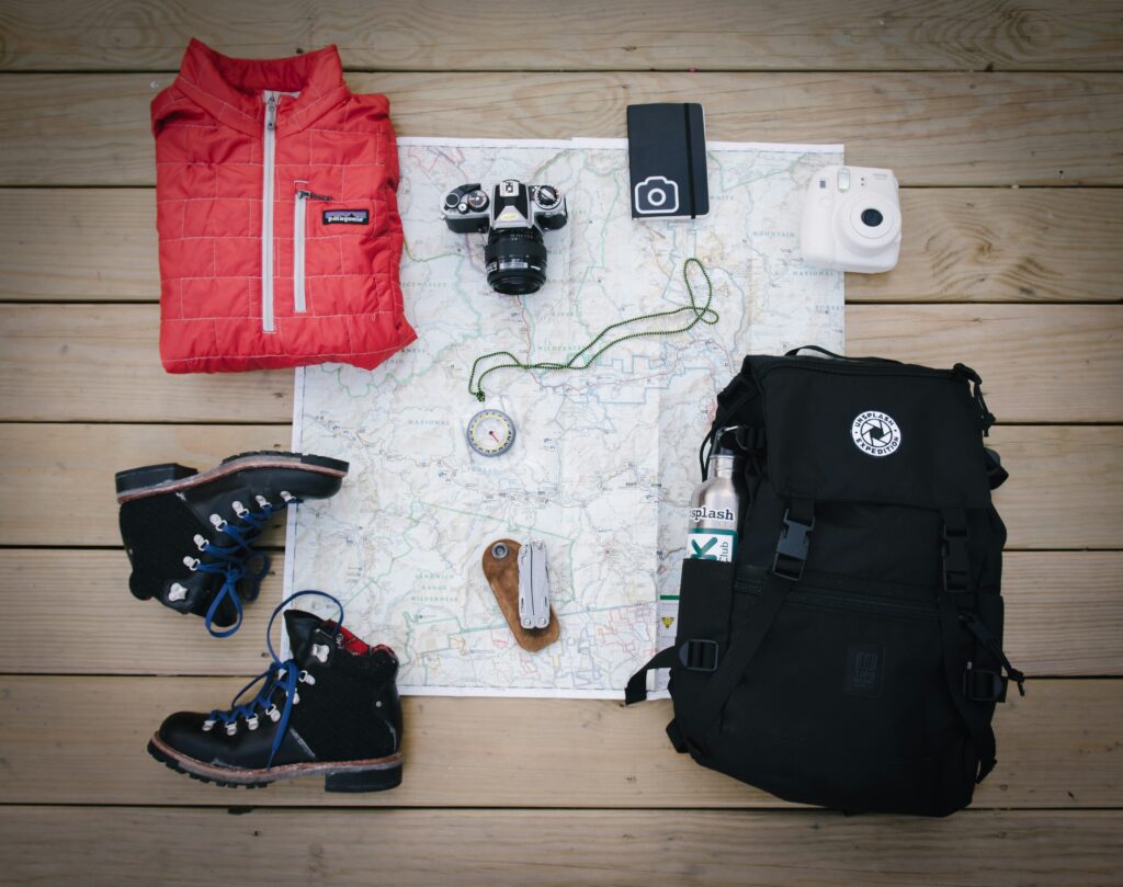 Hiking gear and map on wooden surface.