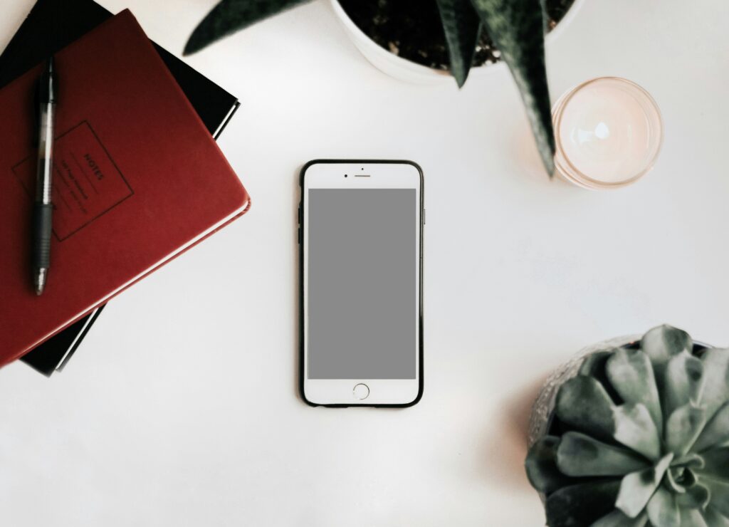 Smartphone, notebook, and plants on a desk