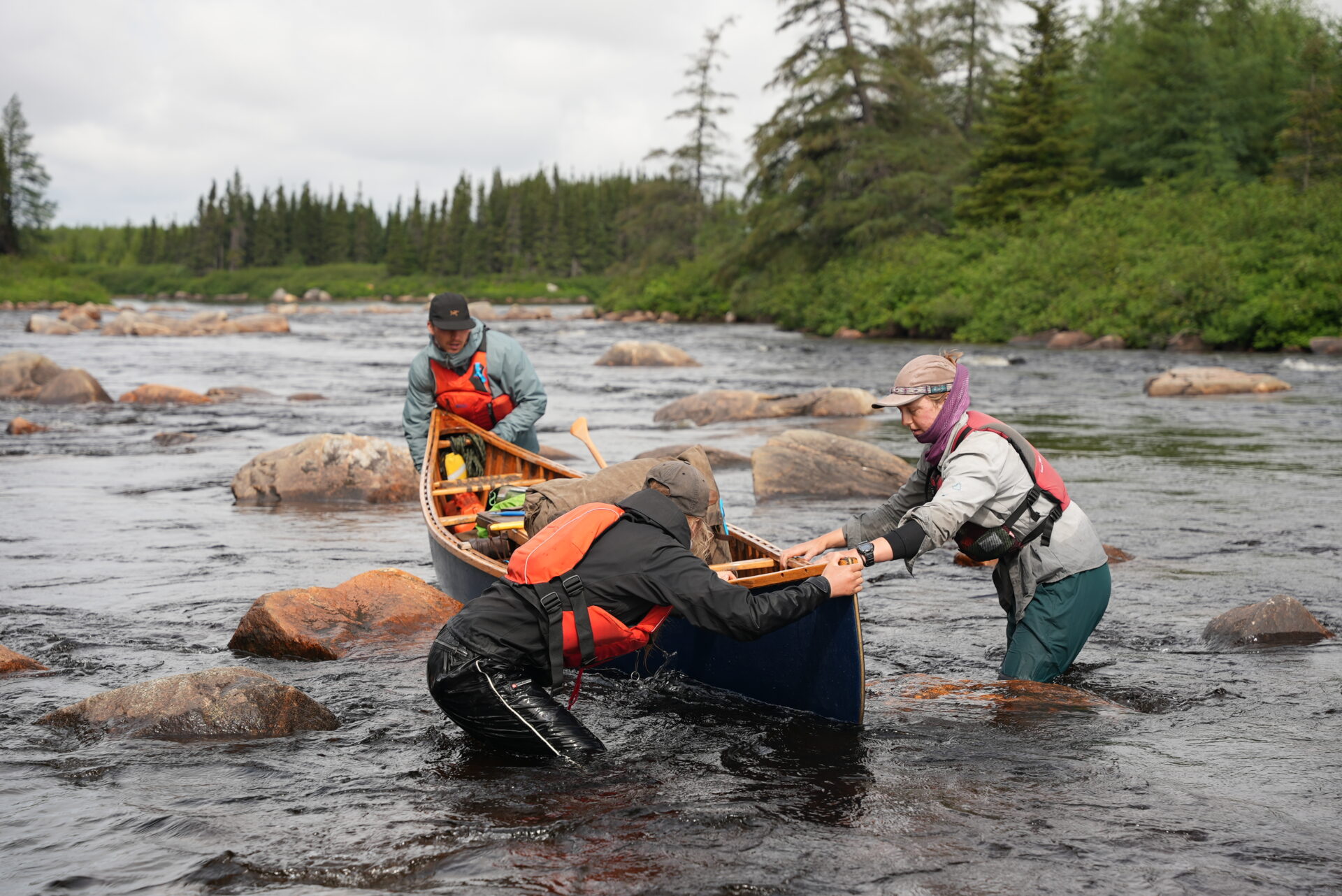 Group navigating canoe through rocky river