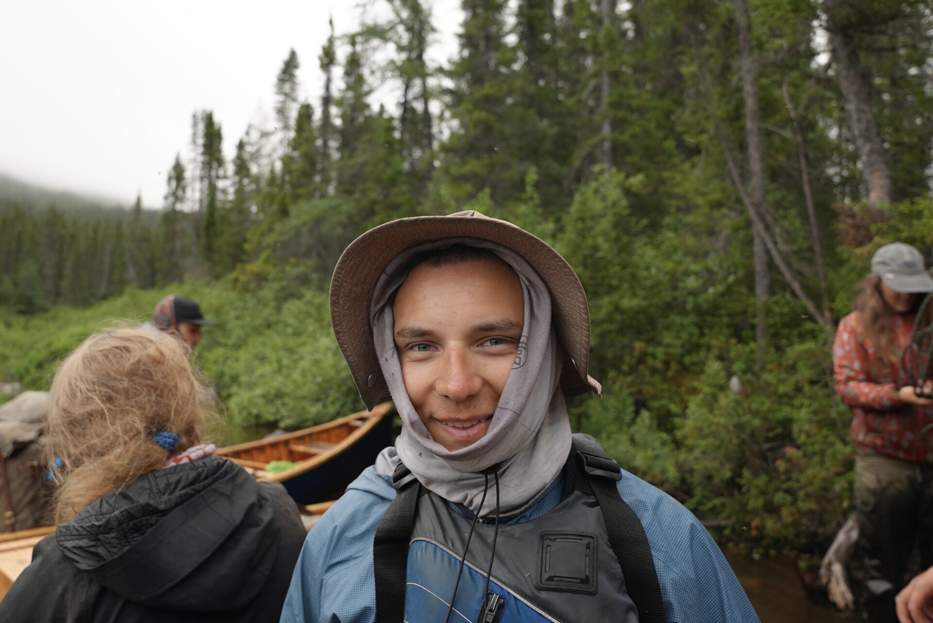 Hiker in forest with hat and gear.