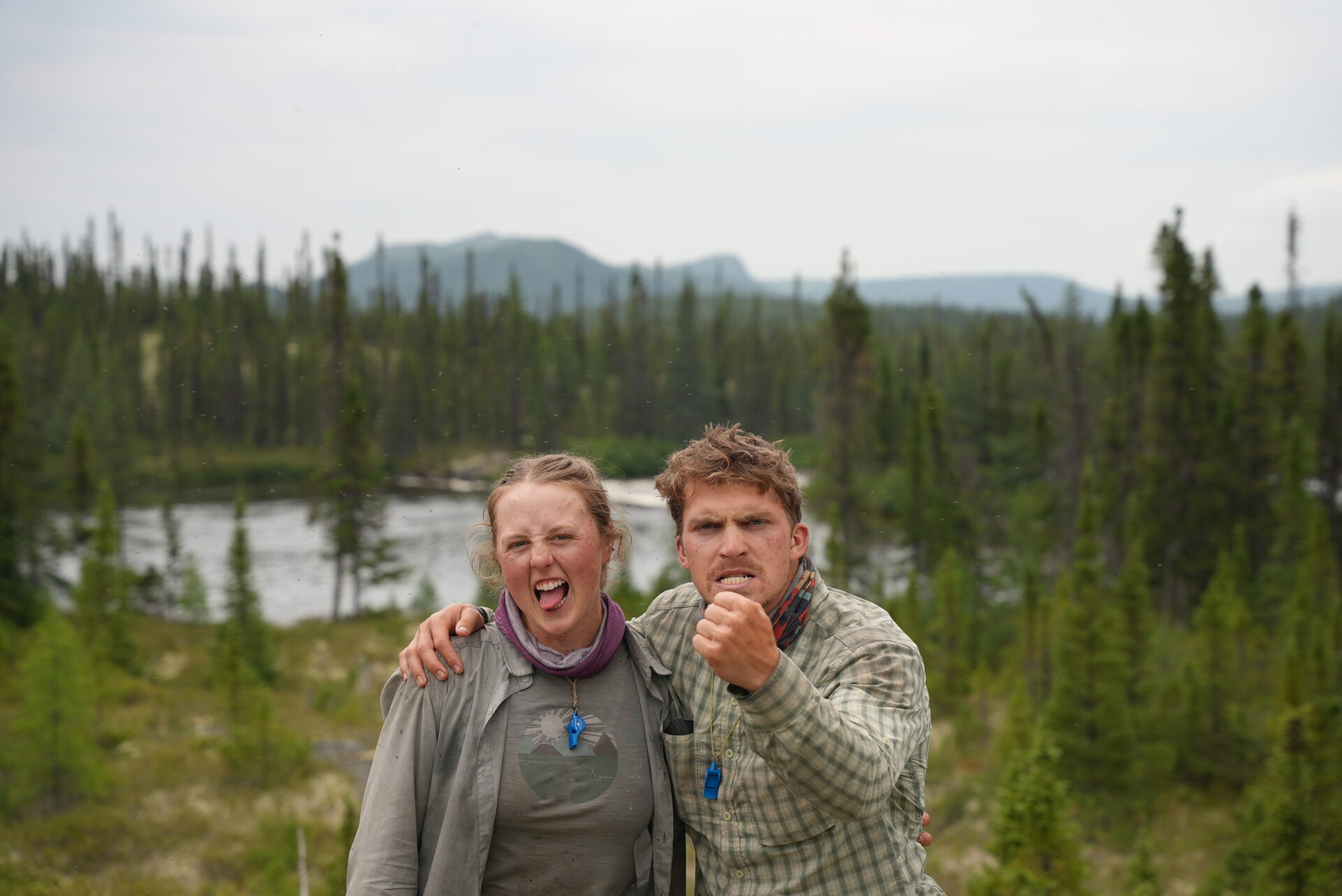 Two people in forest, facial expressions determined.