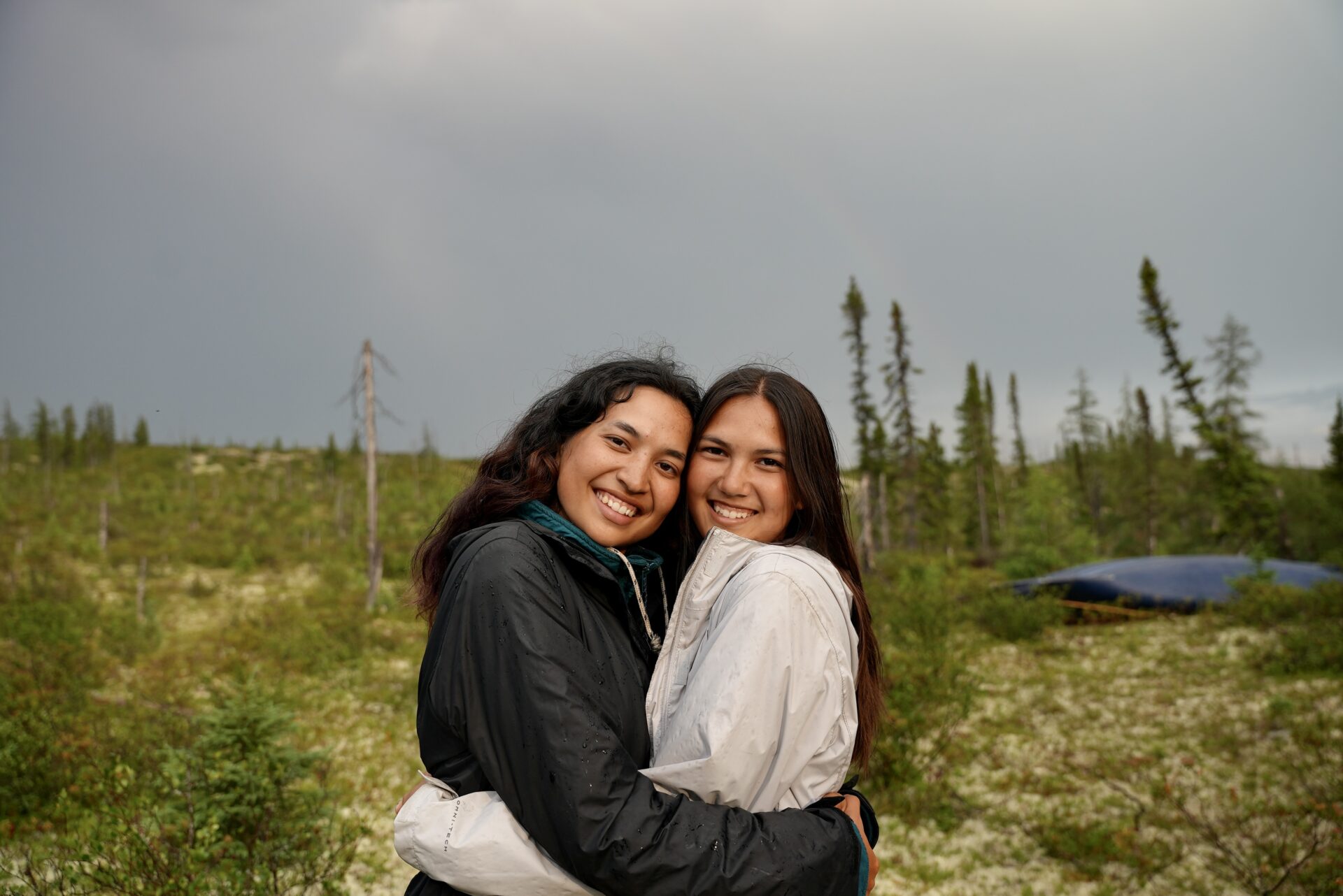 Two friends hugging outdoors in nature