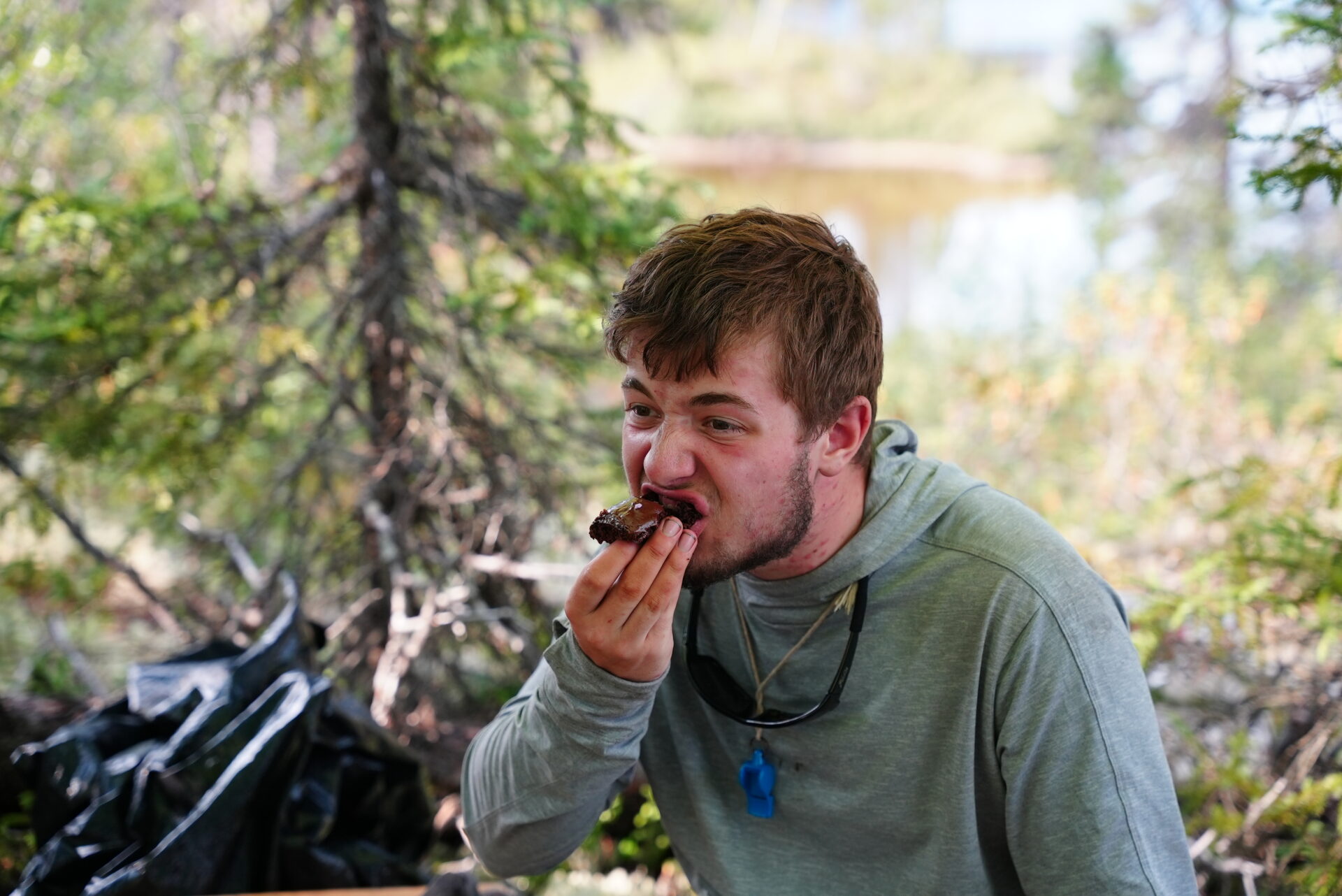 Man eating a brownie in a forest