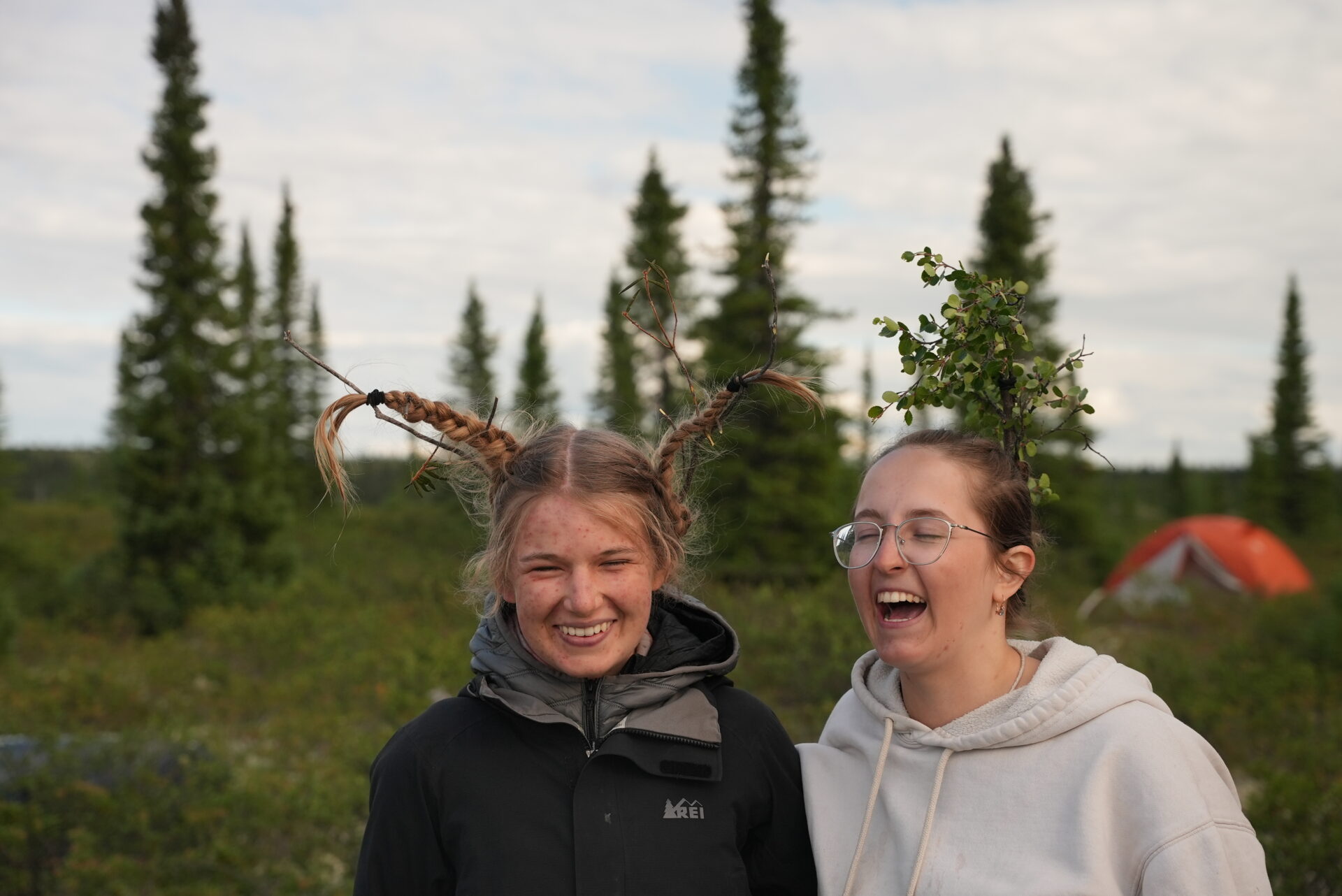 Two friends with unique hairstyles outdoors.