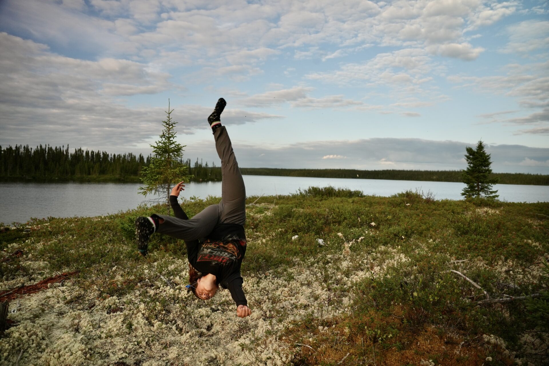 Person doing a flip near a lake.