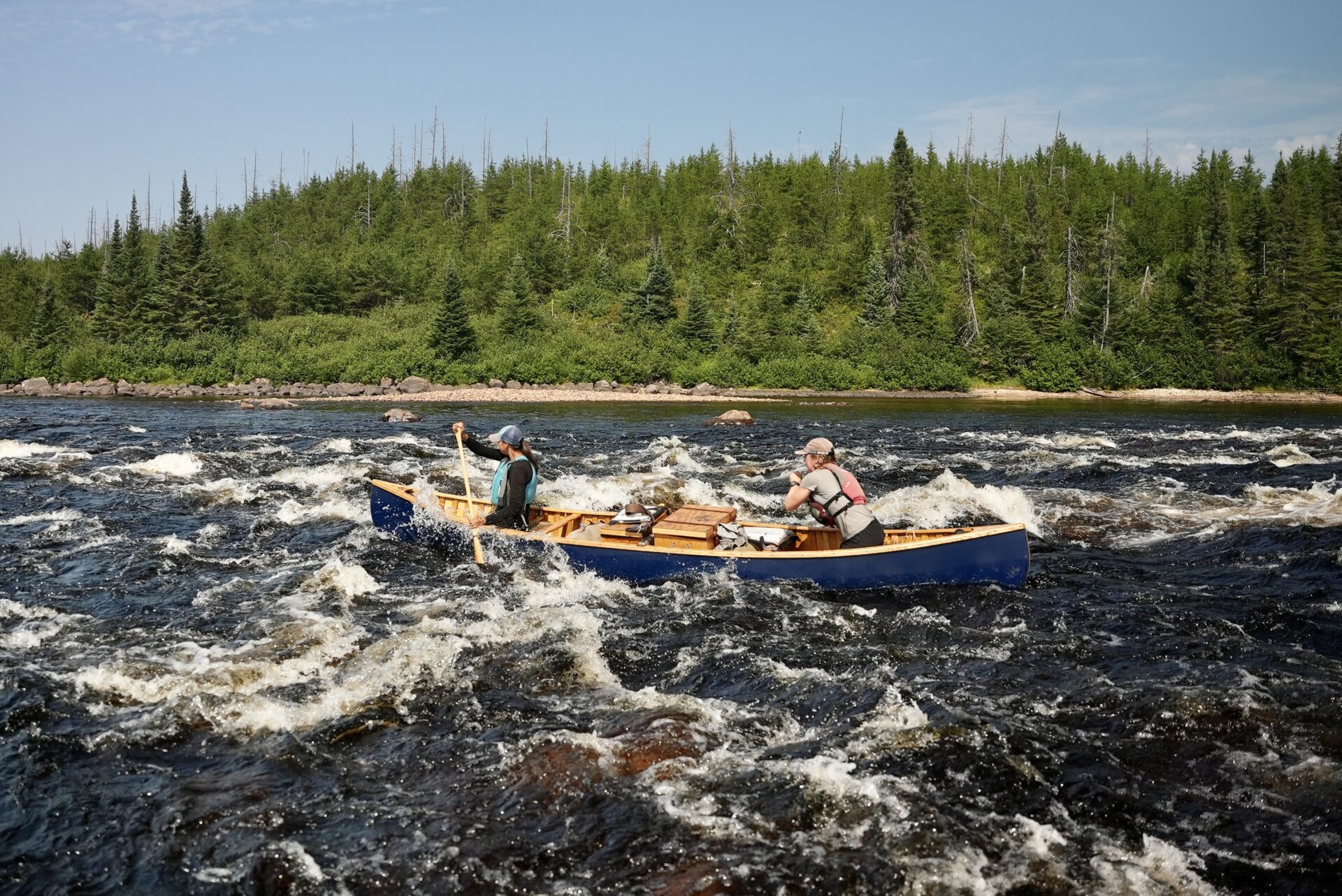 Two people canoeing in rapids