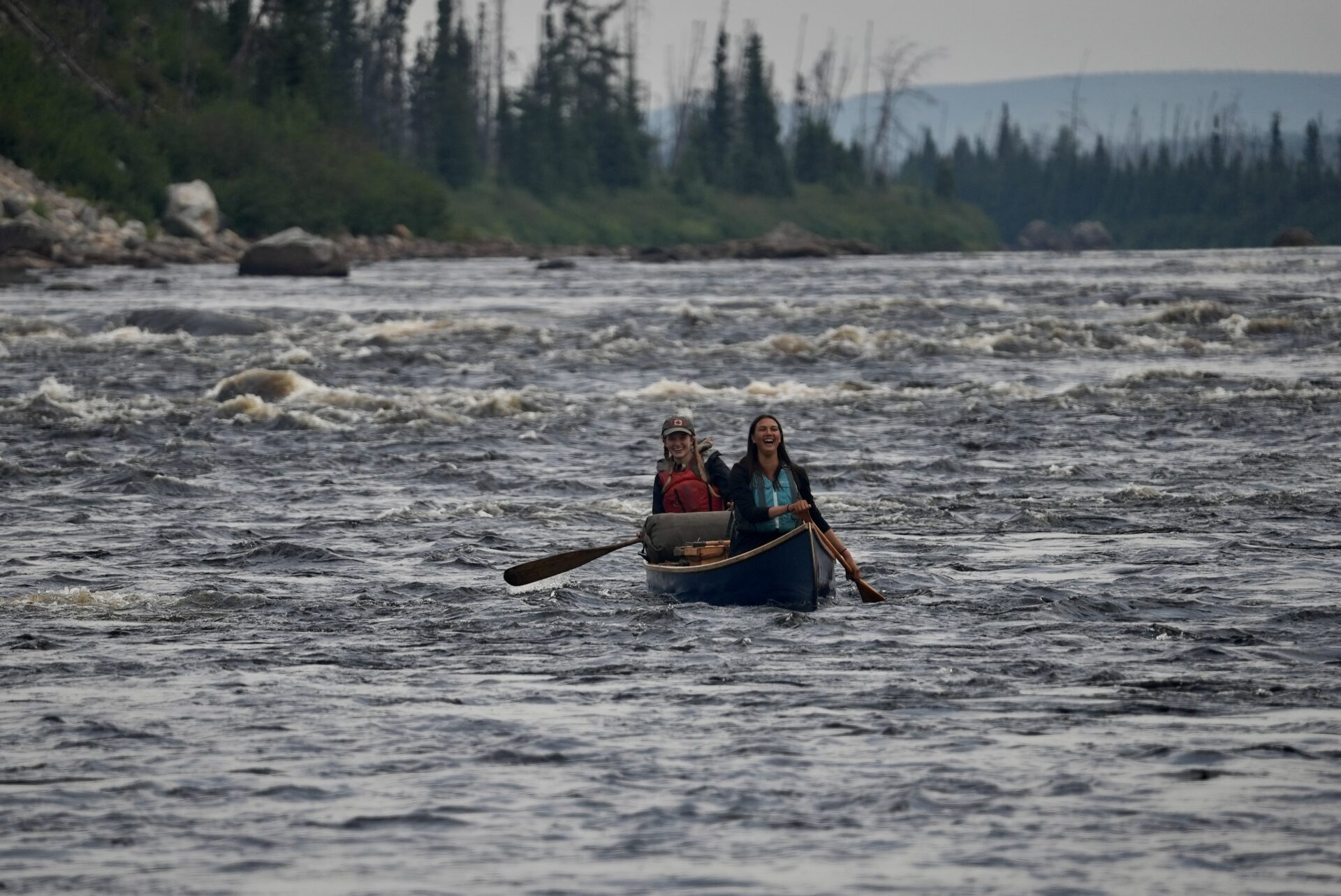 Two people canoeing on a river