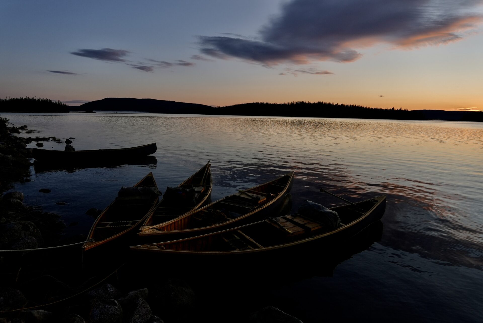 Canoes on a lake at sunset.