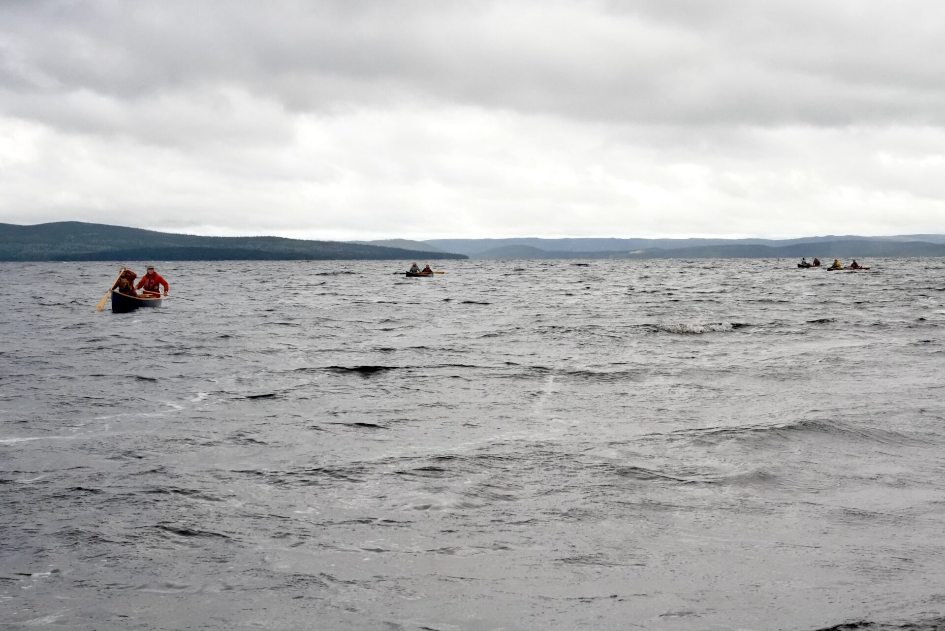 People canoeing on a cloudy lake