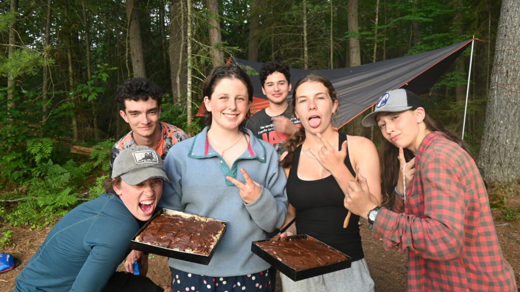 Group of teens camping with baked desserts