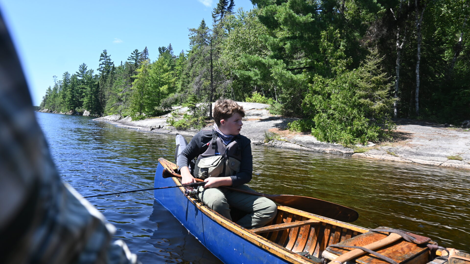 Boy fishing in a canoe on a lake