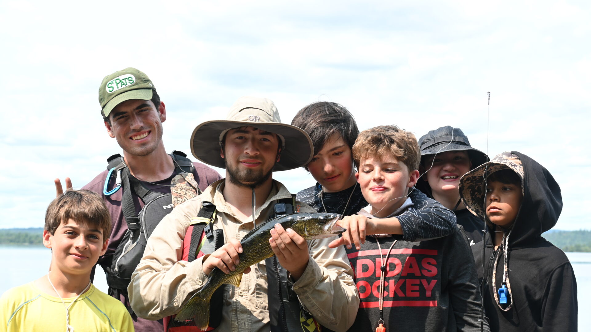 Group of kids holding a fish outdoors