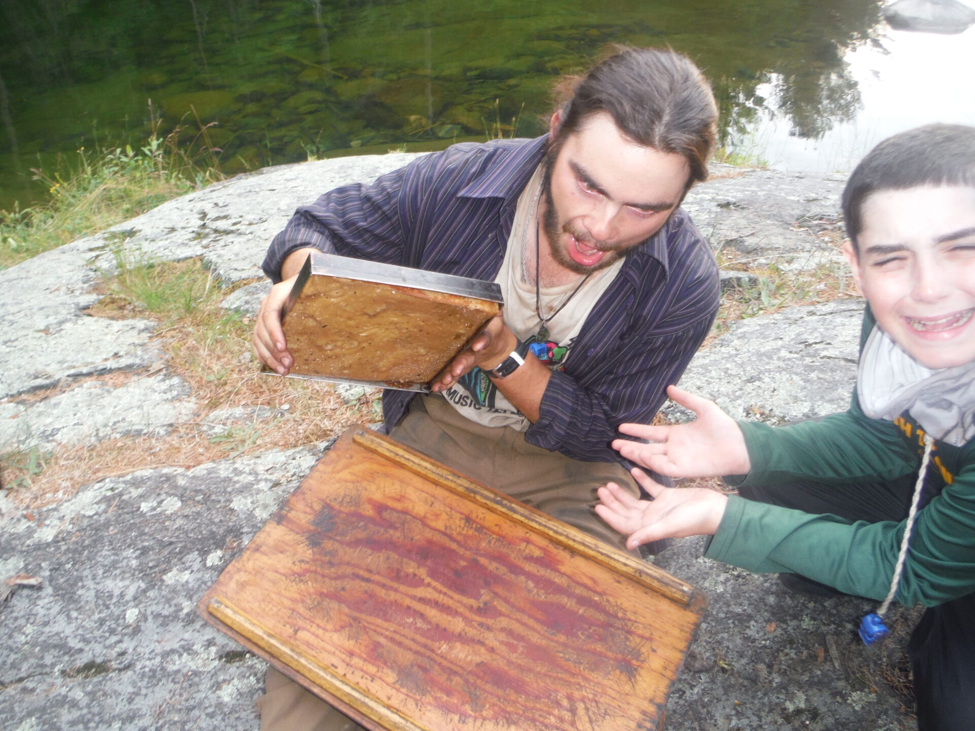 Two people outside with a wooden box.