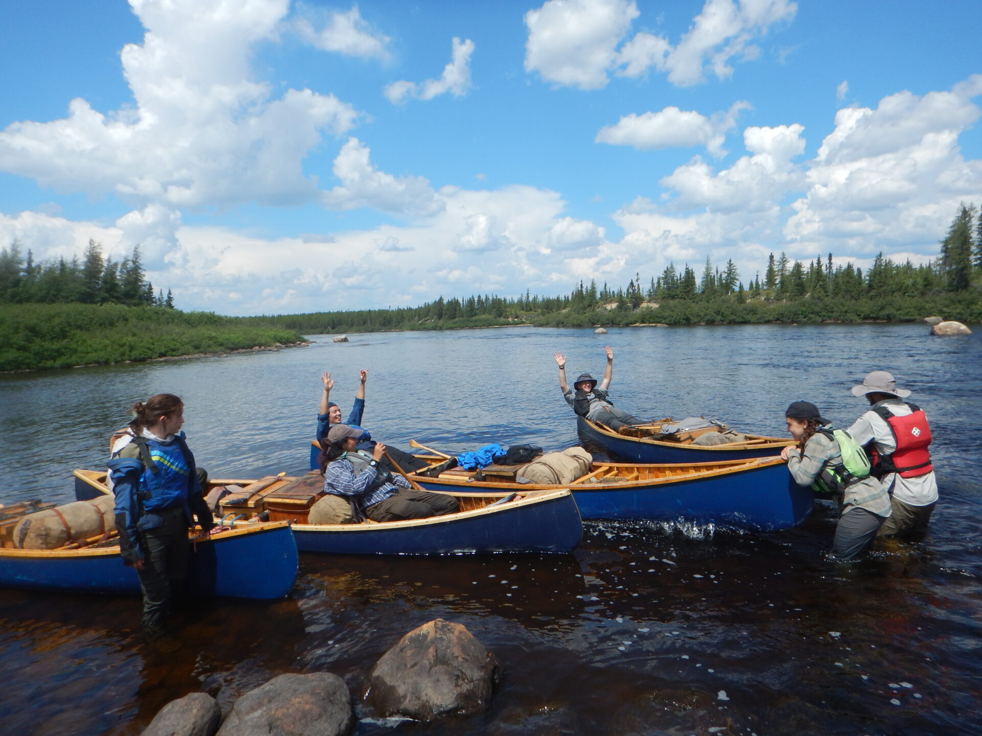 Group enjoying canoeing on a river in nature.