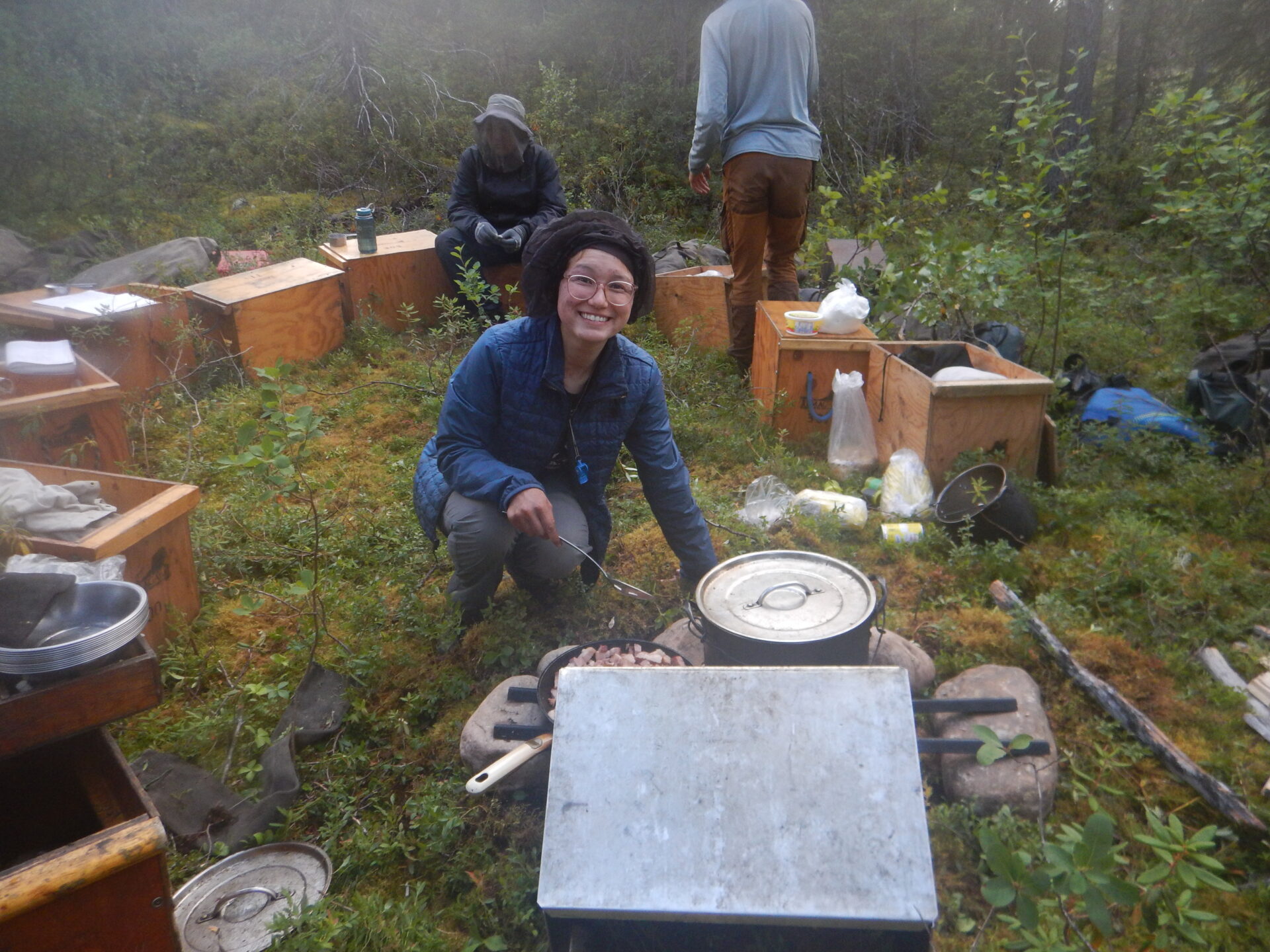 Group camping and cooking in a forest.