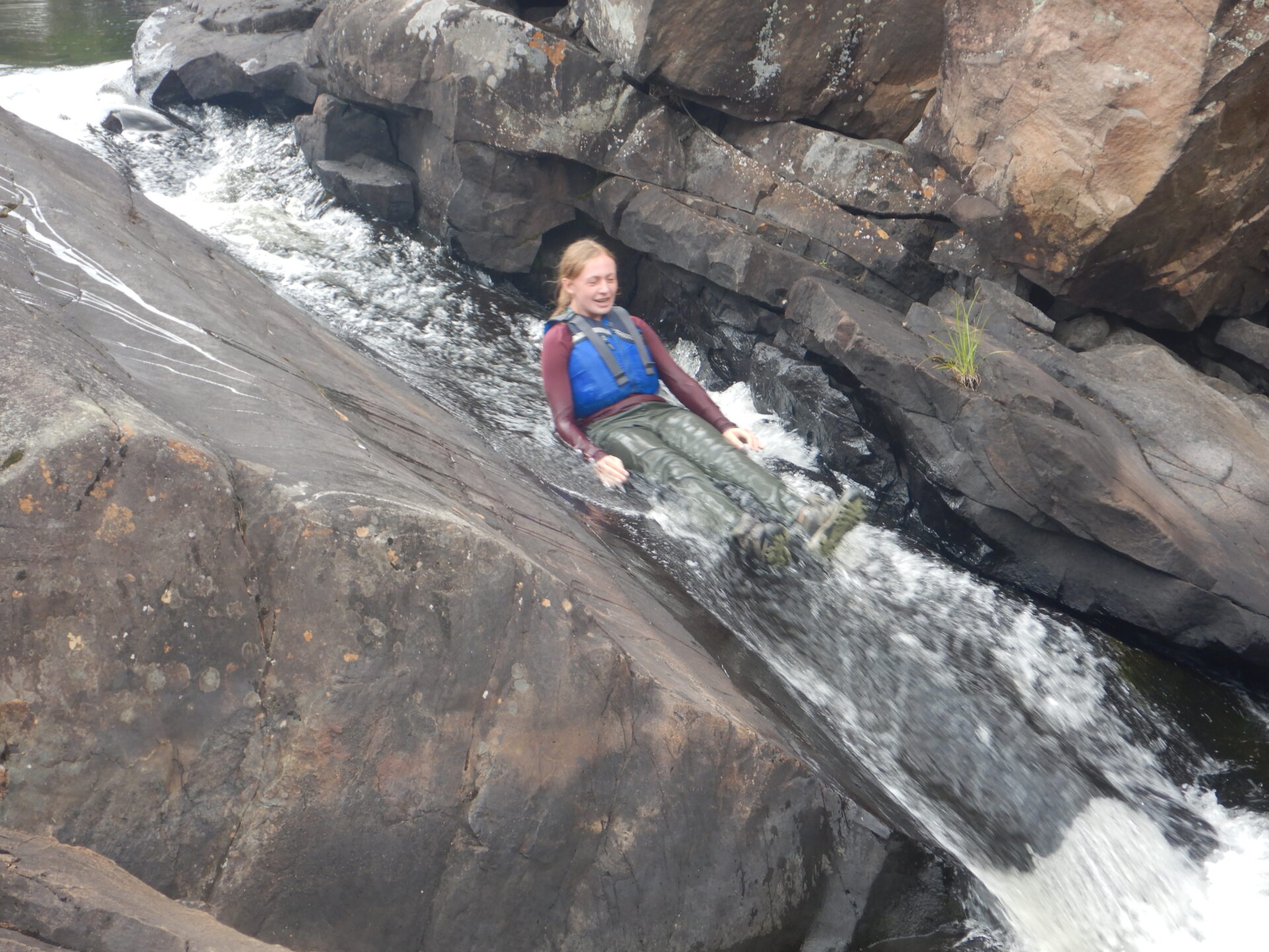 Person sliding down rock water slide