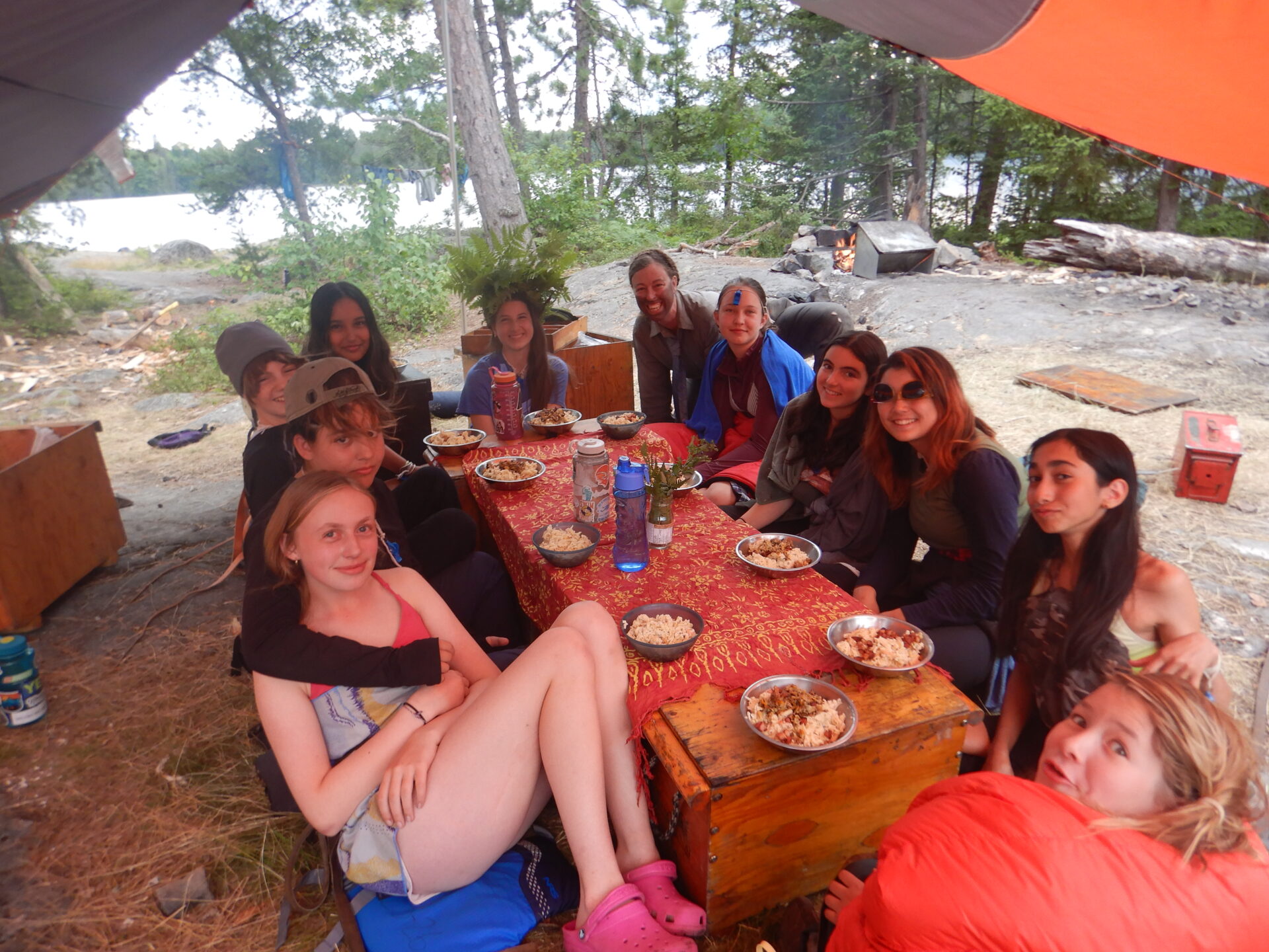 Friends enjoying a meal outdoors while camping.