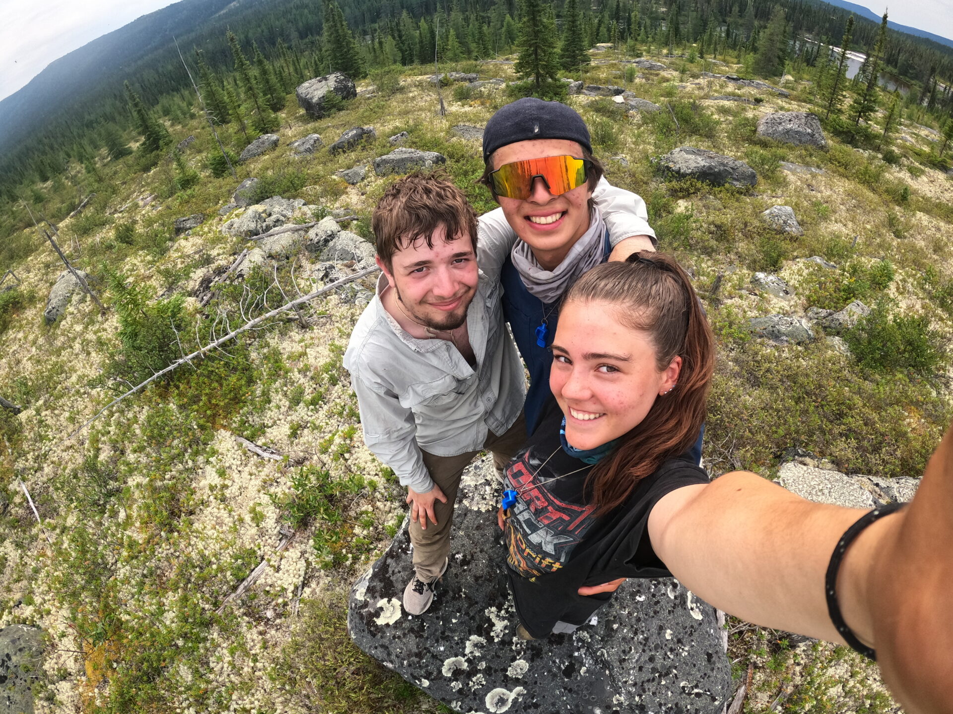 Three friends hiking in a forested area.