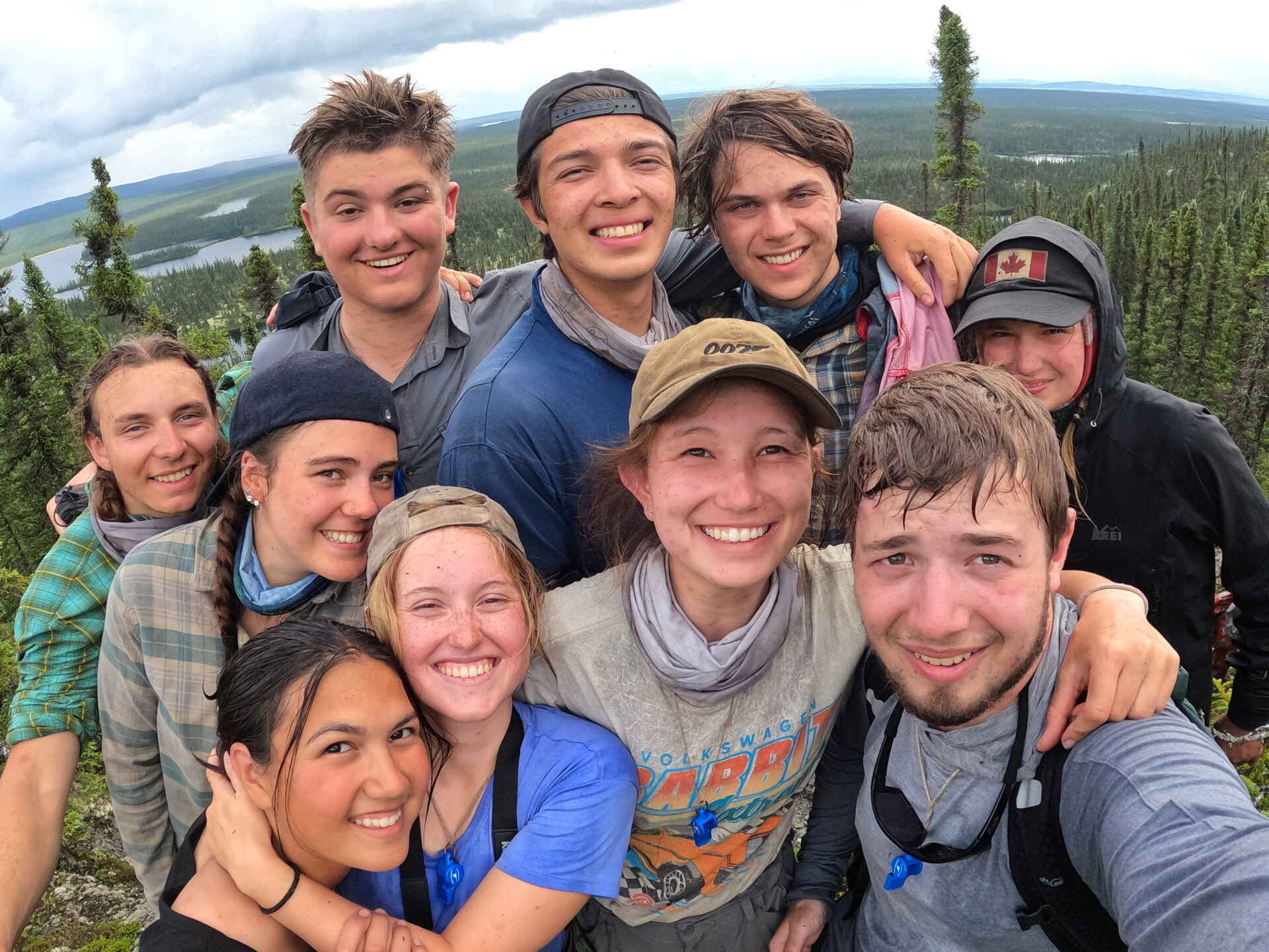 Group of hikers smiling on a forest trail.