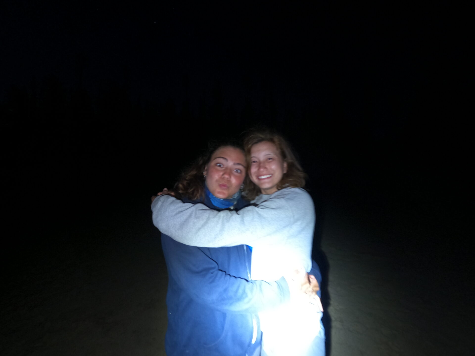 Two people hugging at night