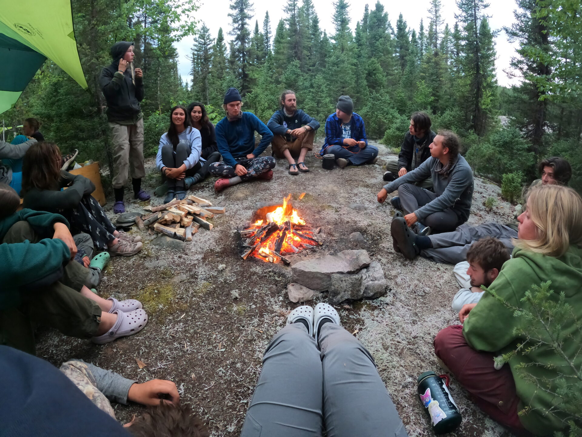 Group sitting around campfire in forest