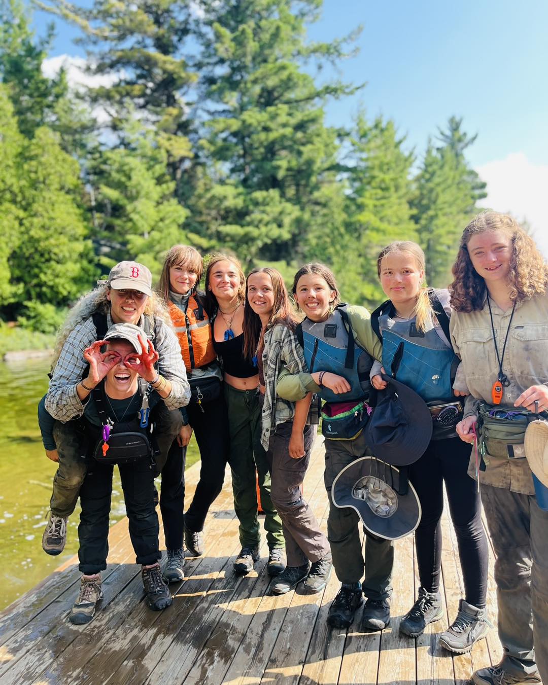 Group of smiling friends on a wooden dock