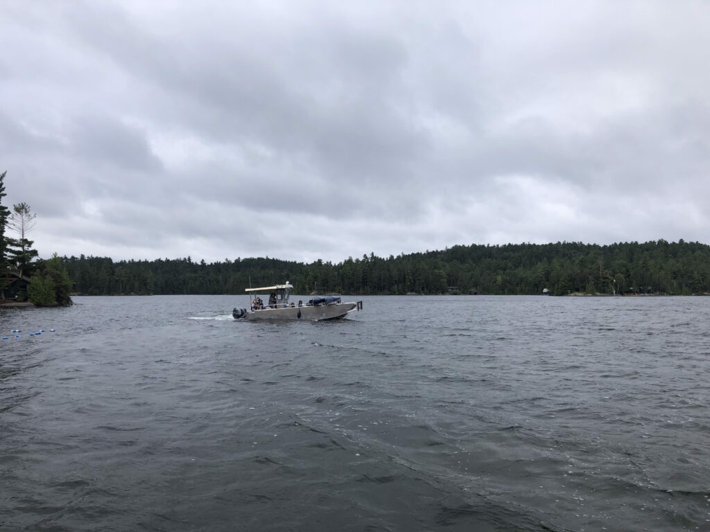 Boat on a lake with cloudy sky.