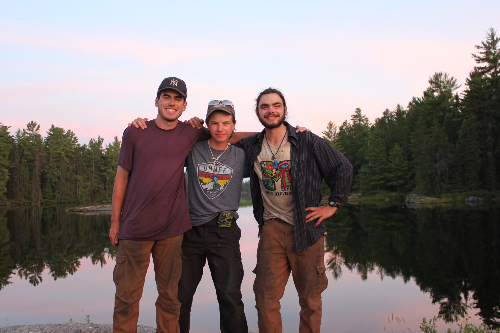 Three friends by a lake at sunset