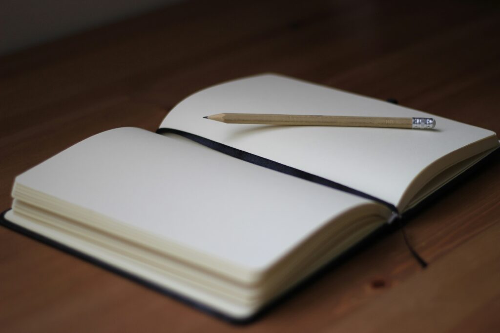 Open notebook with pencil on top.