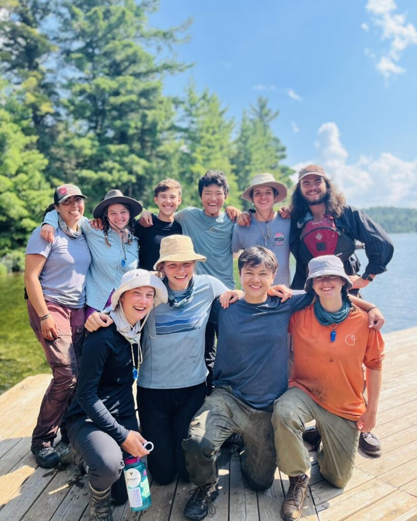 Group of friends outdoors by a lake.