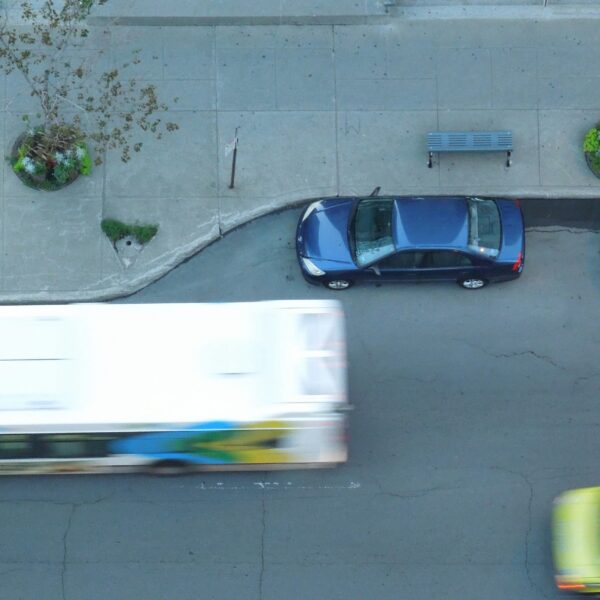 Street with parked cars, bus, and ambulance