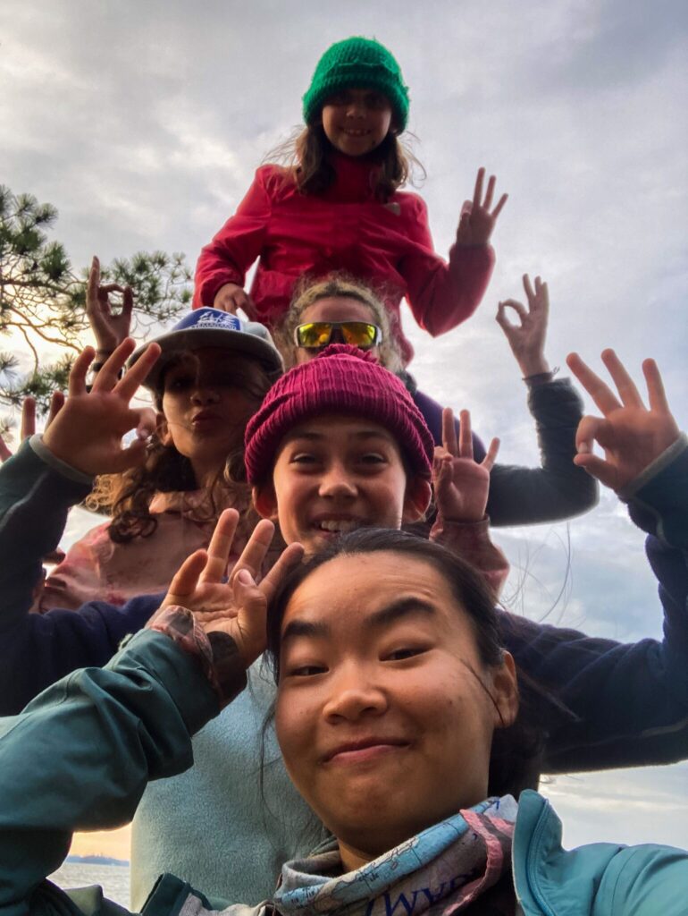 Group of friends making hand signs outdoors.